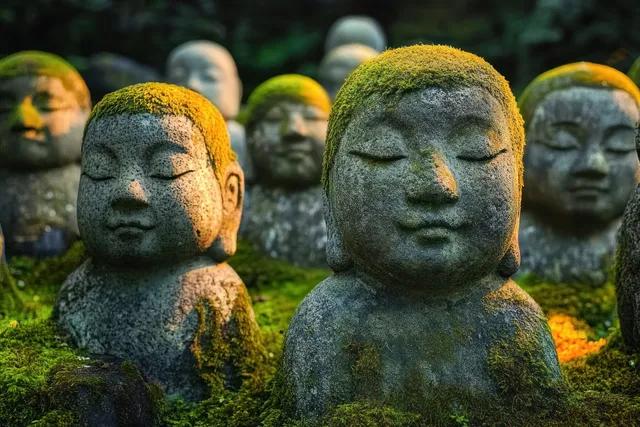 Mossy stone bodhisattva statues stand in a Kyoto temple garden as golden light filters through greenery.