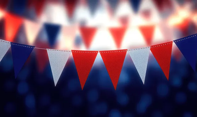 Red white blue triangular pennant banners hang across the frame with glowing string lights behind them.