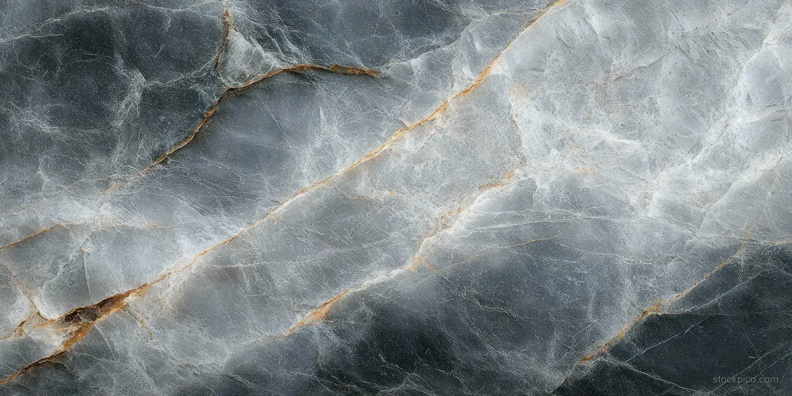 Grey stone surface with cracks, white veining, and orange-brown mineral lines in close-up detail.