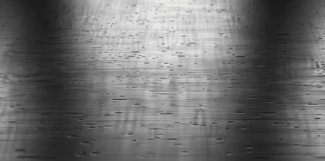 Brushed stainless steel texture with subtle scratches and streaked reflections in grey industrial lighting
