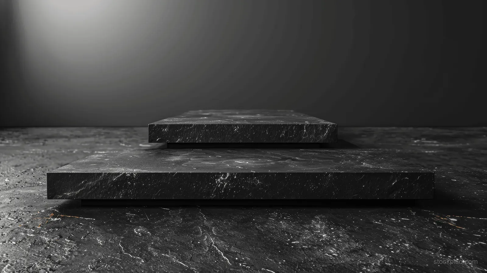 Black wooden blocks sit on dark stepped pedestals in a spotlighted studio with a textured floor.