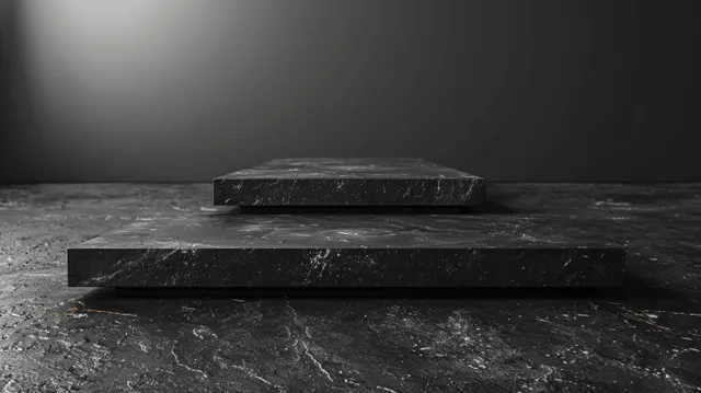 Black wooden blocks sit on dark stepped pedestals in a spotlighted studio with a textured floor.