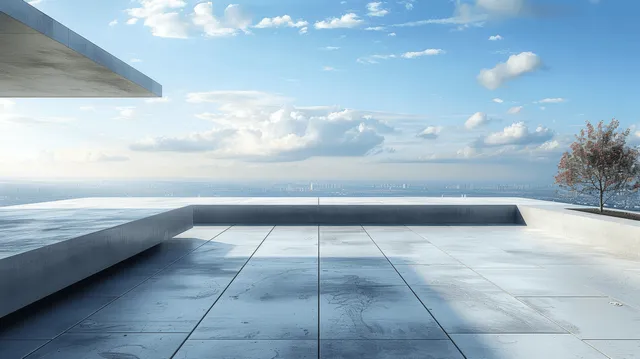 Minimal concrete rooftop terrace with ocean horizon view, low planter edge, and a single tree under partly cloudy sky.