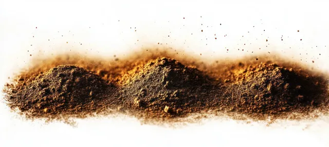 Three uneven mounds of finely ground brown powder sit on a white surface with scattered grains around them.