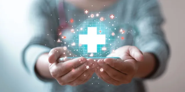 Doctor holding smartphone with digital medical cross icon over patient care interface