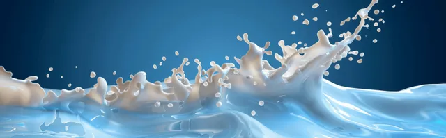 Realistic milk splash arcing across a vivid blue background with droplets and motion blur