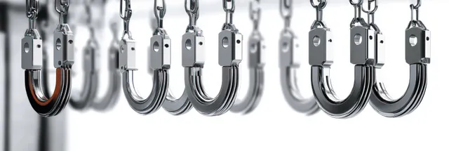 Reflective U-shaped metal hooks hang from metal chains in a row against a white background.