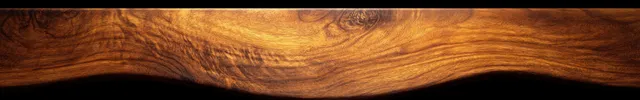 Close-up of warm brown wood grain texture with smooth flowing lines and natural surface detail.