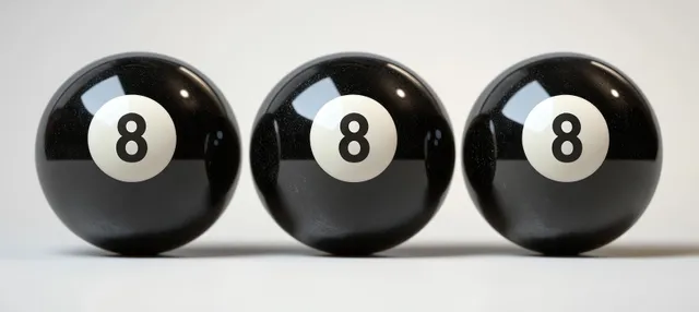 Three glossy black eight billiard balls with number 8 aligned in a row on a white surface.