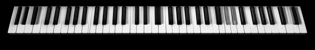 Horizontal full piano keyboard with black and white keys isolated on a black background.