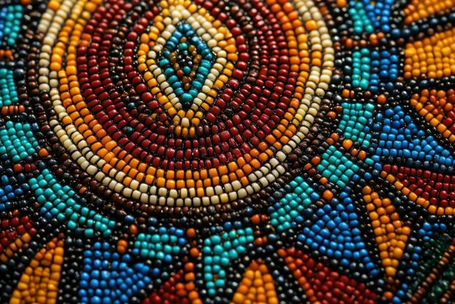 Close-up of multicolor beadwork with circular and diamond patterns forming a textured geometric medallion surface.