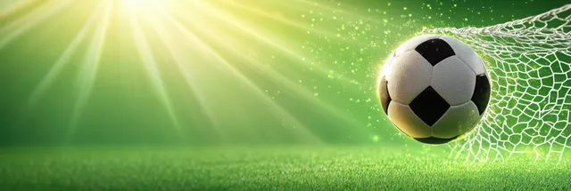 A soccer ball hits the goal net with sunburst light over a green football field.