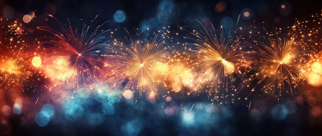 Colorful fireworks burst over dark blue night sky with golden bokeh lights