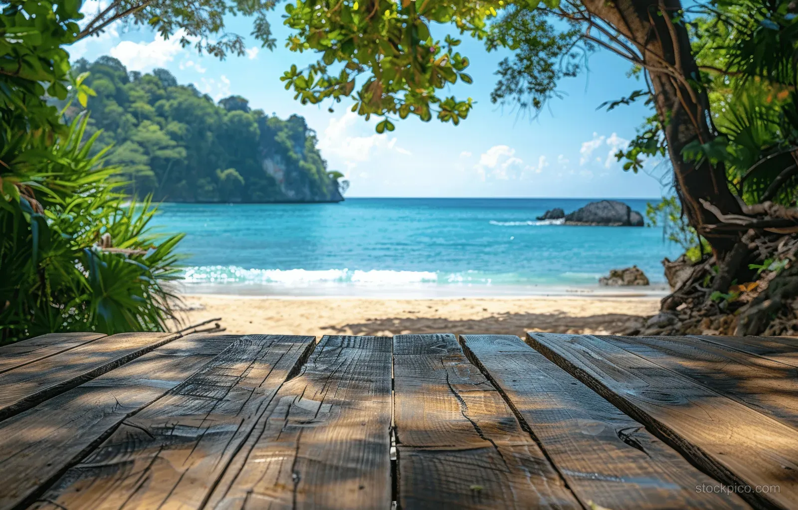 Weathered wooden tabletop overlooking a tropical beach and turquoise water.