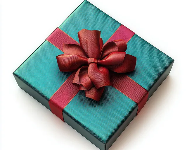 Square turquoise gift box wrapped with shiny deep red ribbon and a large bow on a white background.