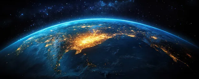 Earth seen from space at night with Asia’s coastline glowing with city lights under a starry sky.
