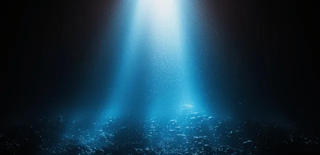 A blue spotlight beam falls over a dark grainy gradient background with glowing particle specks.