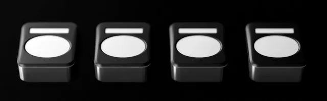 Four black rectangular storage containers with white oval labels lined up in a row
