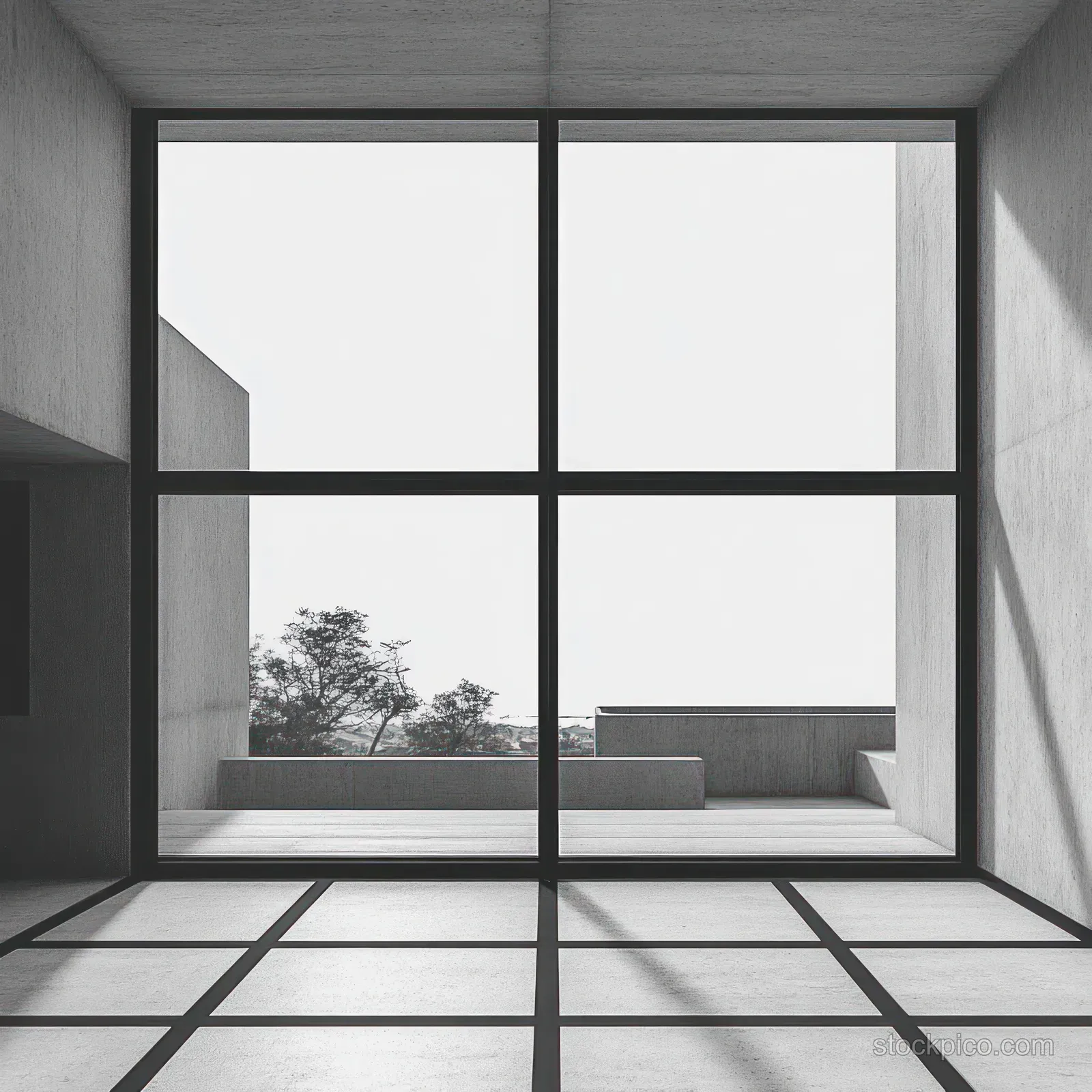 Minimalist interior showing a grid window casting shadows across a concrete floor and a terrace with trees outside.