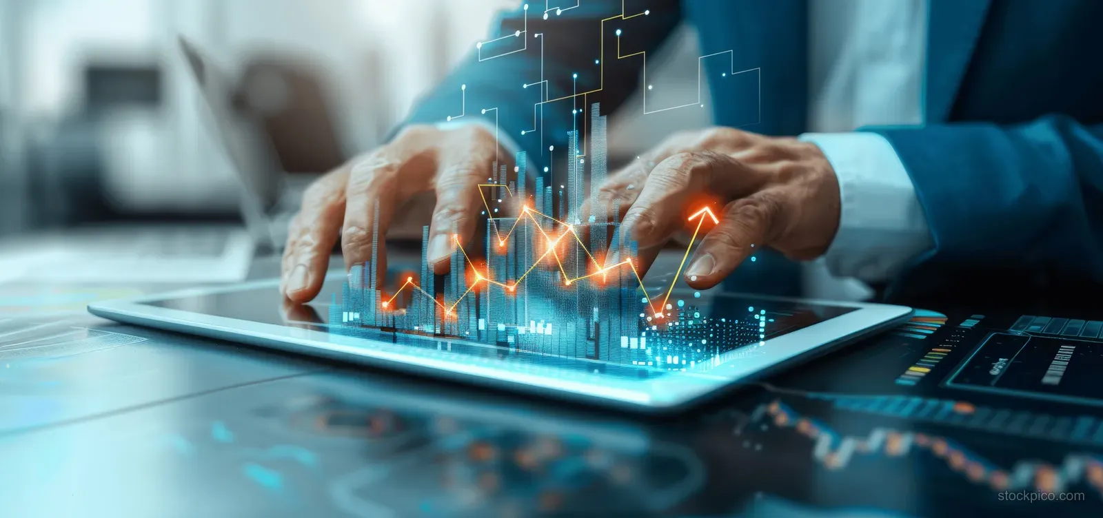A businessman’s hands analyze a tablet screen showing glowing upward growth charts in an office setting.