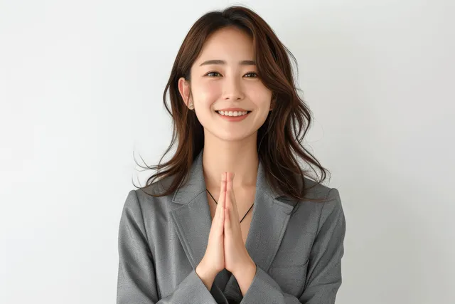 Smiling Japanese businesswoman making a peace sign in a studio portrait