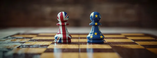 UK and EU flag pawns stand on a chessboard with blurred sides and soft lighting.