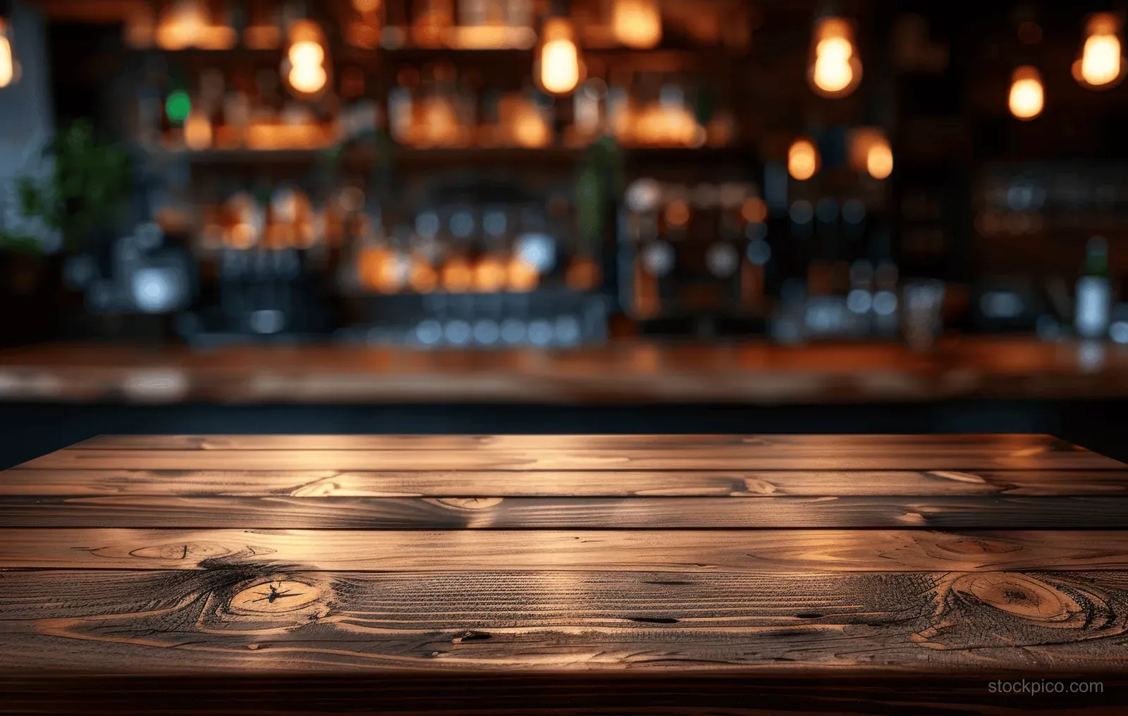 Close-up of a wooden table in a cozy bar with warm lights and softly blurred bottles behind it.