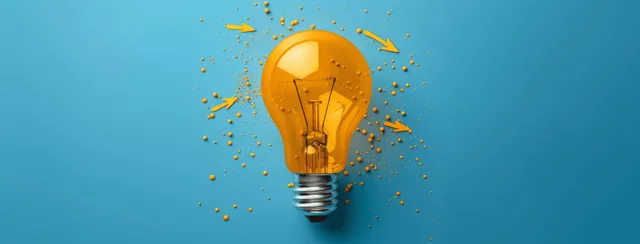 Golden glowing lightbulb with sparking particles on a blue background representing innovation and business ideas.