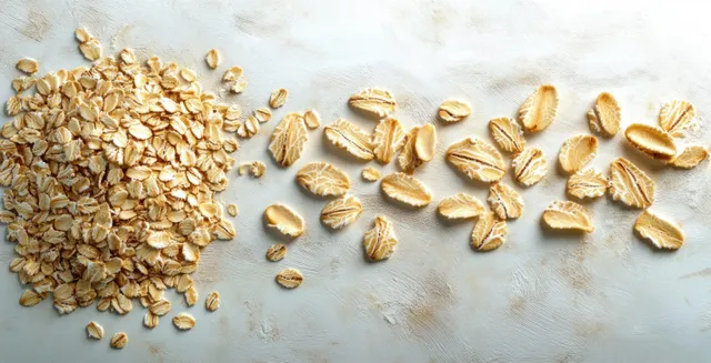 Rolled oats pile with scattered oat flakes on a light textured surface