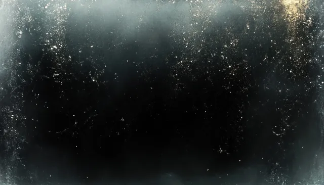 Shimmering cosmic dust particles drift through a dark grayscale background with gritty film-grain texture.