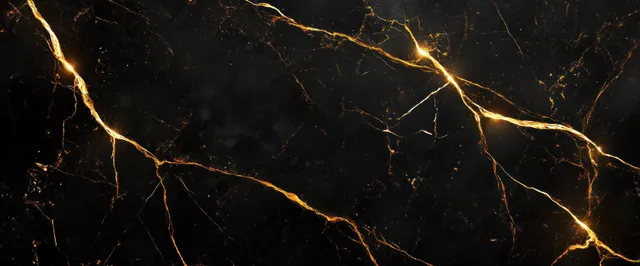Close-up of black marble with glowing golden veins under moody ambient lighting.