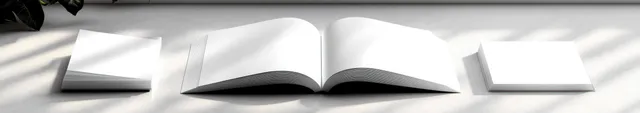 Open blank book on light marble surface with soft natural light and shadows