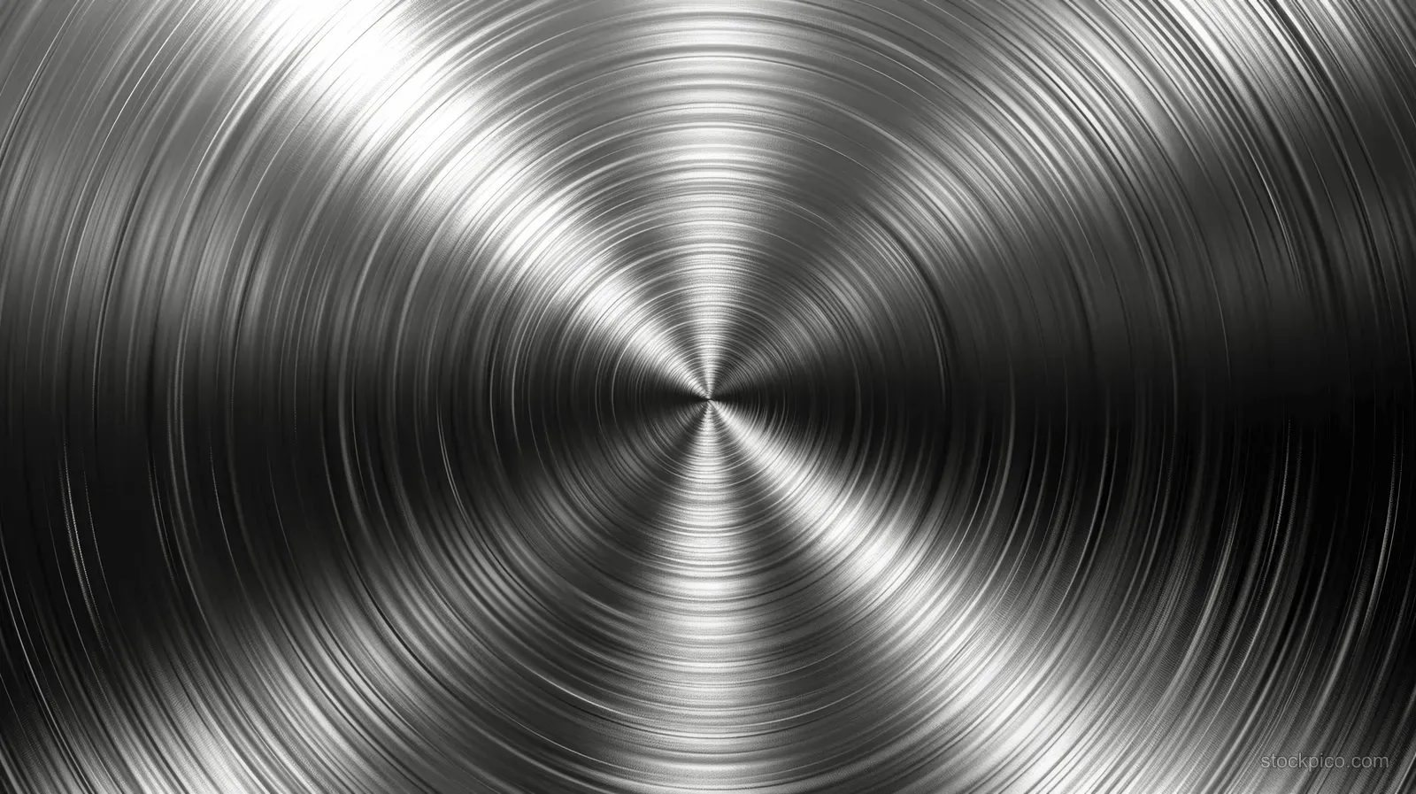 Brushed stainless steel surface with concentric circular grooves radiating from a central point.