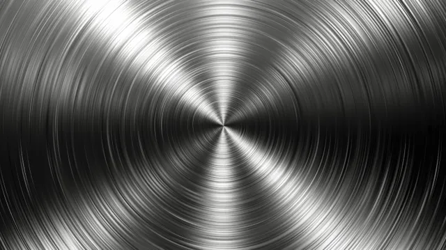 Brushed stainless steel surface with concentric circular grooves radiating from a central point.