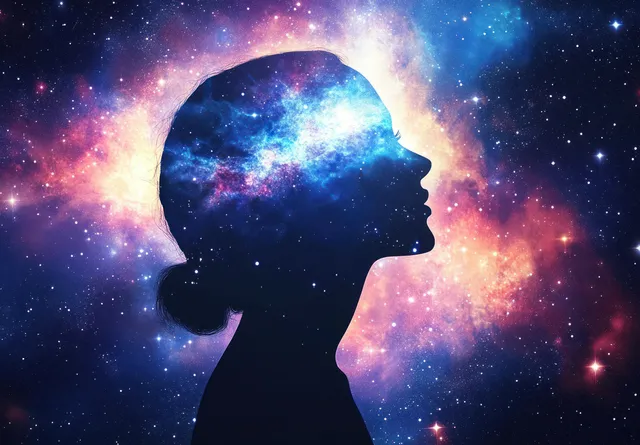 Silhouette of a meditating figure with glowing chakra colors against a colorful cosmic nebula sky.