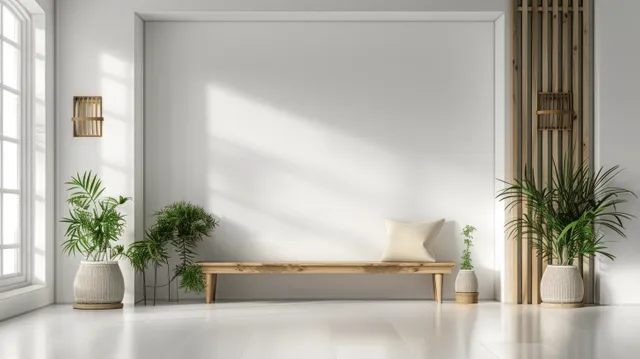 Minimalist living room interior showing a blank white wall, wooden bench, and potted plants in front of soft window light.