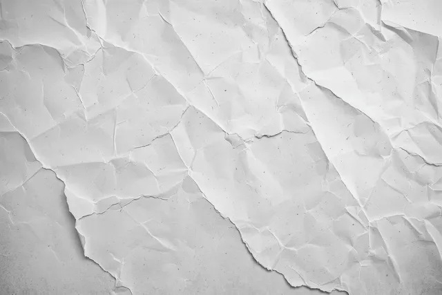 Cracked white concrete wall texture with weathered plaster wrinkles and subtle grey mottling
