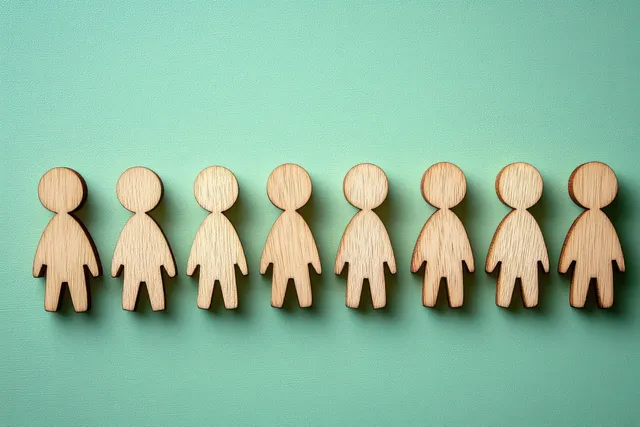 Row of eight wooden human figures evenly spaced on textured teal background