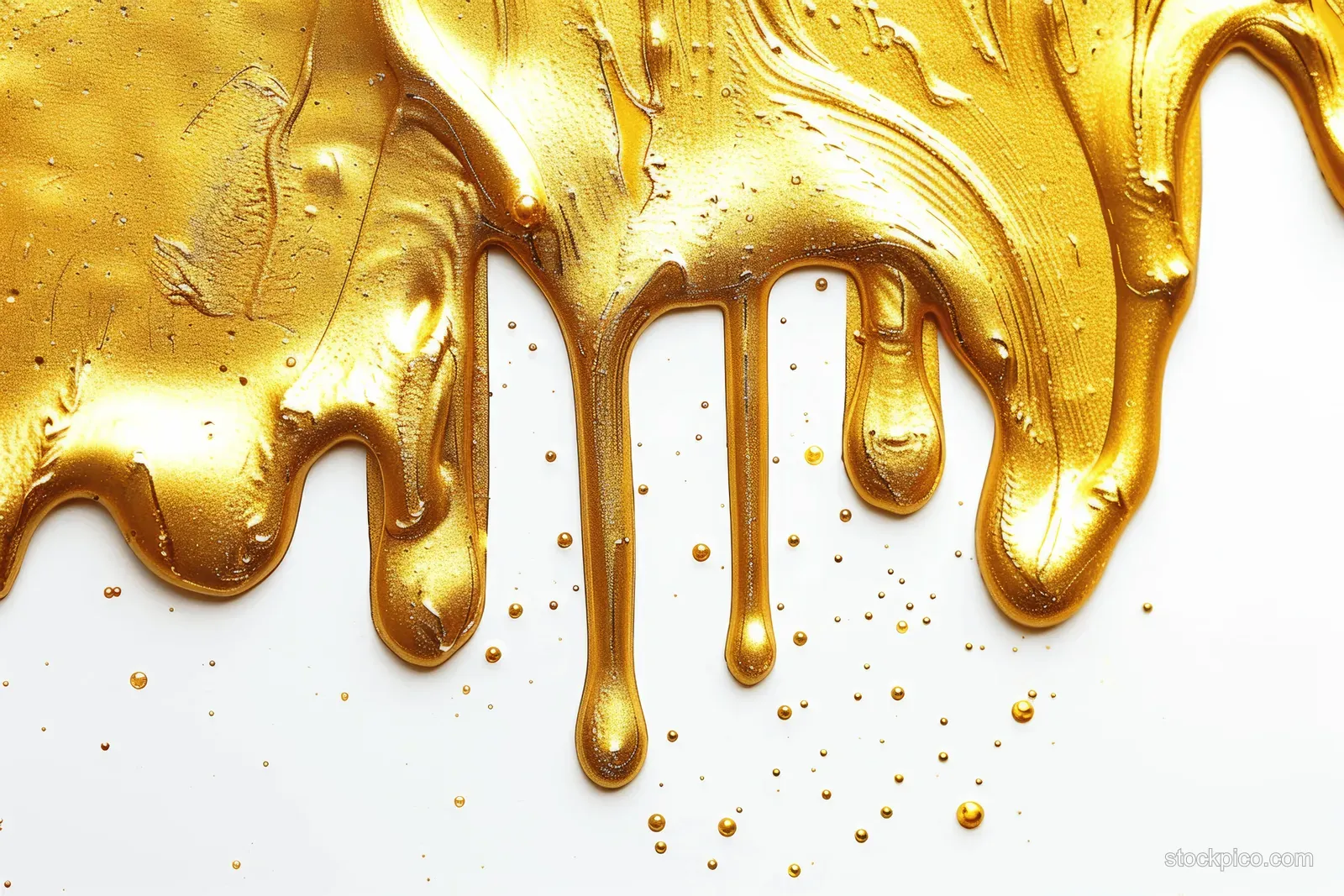 Gold acrylic paint drips over a bright white surface with small splatters and wet textured streaks.