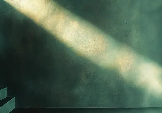 An empty room corner with textured green wall, a few steps, and diagonal soft sunlight creating shadows.