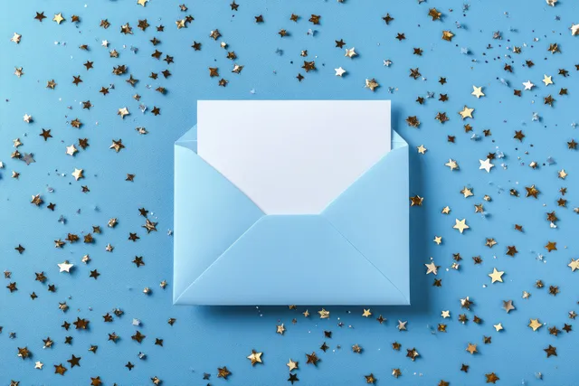 Open light blue envelope on a blue surface surrounded by gold and silver star confetti.