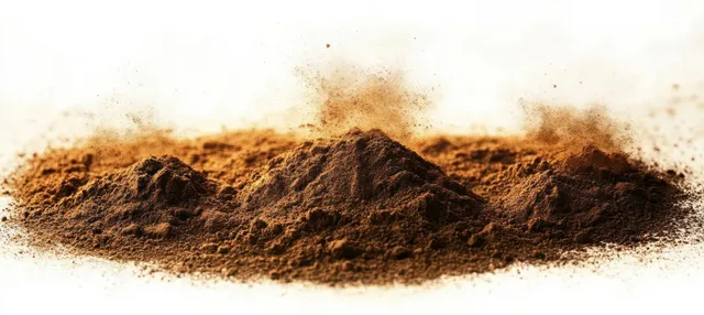 Close-up of three brown powder piles with fine dust particles dispersing into the air on a white background.