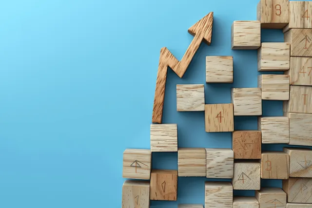 Hand stacking wooden blocks to rise interest rate chart with blue economic background
