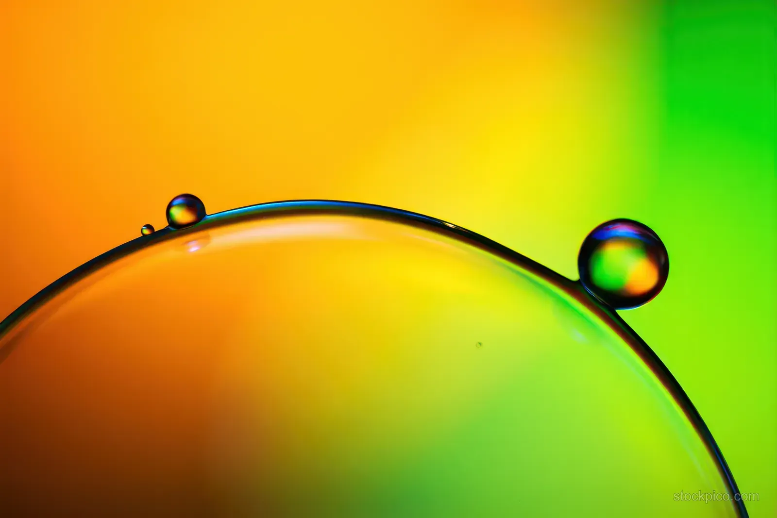 Colorful transparent bubble film with tiny droplets sits on a curved surface against a yellow-green gradient background.