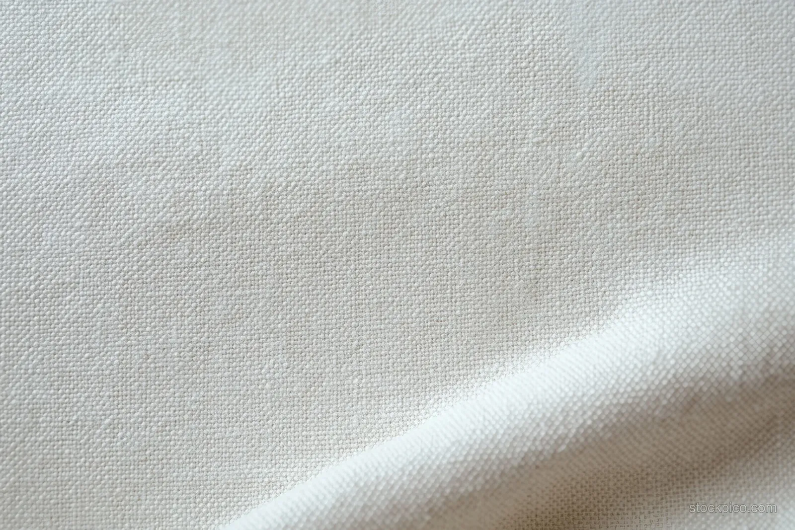 Cream paper-canvas close-up with fine grain, subtle ripples, and soft fold shadows in neutral tones.