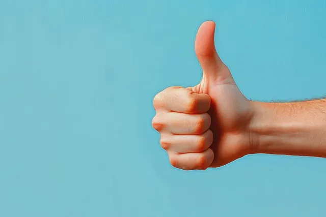 Female hand gives a thumbs-up against a pastel blue minimalist background.
