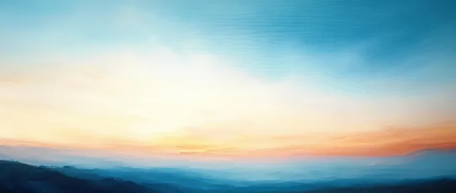 Pastel sunrise sky over distant landscape with soft orange glow