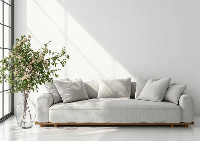 Gray sofa with plush cushions and fresh flower vase in bright Scandinavian living room
