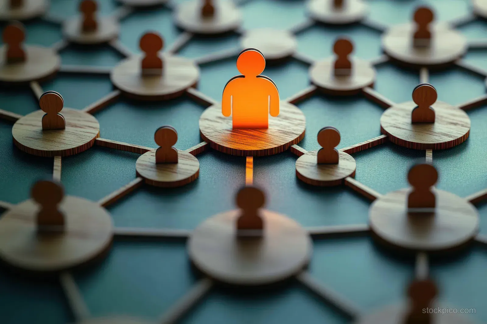An orange glowing wooden leader figure stands among smaller wooden person icons connected by network lines on a teal board.