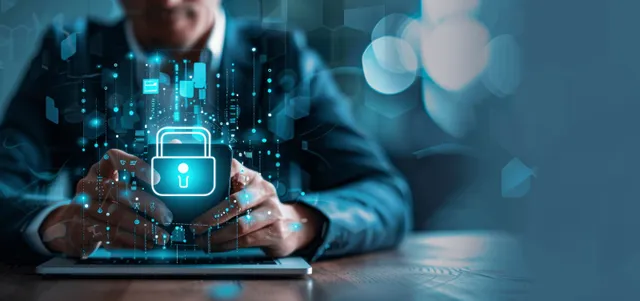 Businessman typing on laptop with smartphone showing digital padlock security overlay